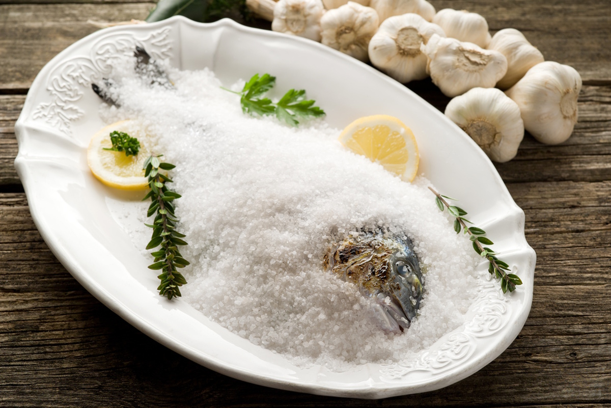 дорадо в соляной корке на белой тарелке